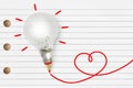 Light bulb with red pencil and heart sketch on striped notebook