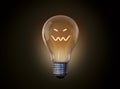 The light bulb squinted and smiles ominously Royalty Free Stock Photo