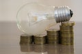 Light bulb on stacks of coins. Savings, accounting and financial concept. Ideas make money Royalty Free Stock Photo