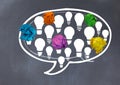 light bulbs chat bubble with crumpled paper balls in front of blackboard