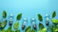 Light bulbs and green leaves on a blue background.