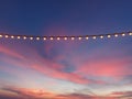 Light bulbs on string wire against sunset sky Royalty Free Stock Photo
