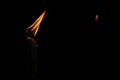 Light of the burning Christmas candle against dark background, close up. Royalty Free Stock Photo