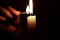 Light candle in darkness with match Royalty Free Stock Photo