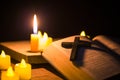 Light candle with holy bible and cross or crucifix on old wooden background in church.Candlelight and open book on vintage wood Royalty Free Stock Photo