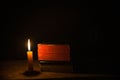 Light candle with holy bible and cross or crucifix on old wooden background in church.Candlelight and open book on vintage wood Royalty Free Stock Photo