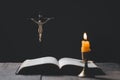 Light candle with holy bible and cross or crucifix on old wooden background in church.Candlelight and open book on vintage wood Royalty Free Stock Photo
