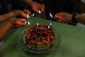 Light Candles on The Crape Cake that on top with Mixed Berries and Strawberry Sauce