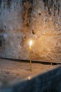 Light candles on the sand. single candle and stone wall.