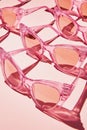 Light casts subtle shadows on a pattern of pink sunglasses on a pink background Royalty Free Stock Photo