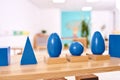 Light class in Montessori kindergarten. The blue Montessori geometric solids in the foreground. nobody