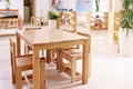 Light class in Montessori kindergarten. wooden children`s table with chairs in the foreground. nobody
