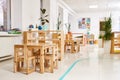 Light class in Montessori kindergarten. wooden children`s table with chairs in the foreground. nobody