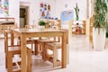 Light class in Montessori kindergarten. wooden children`s table with chairs in the foreground. nobody