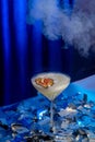 Light cocktail in a tall glass on a blue shiny background with glitter. Royalty Free Stock Photo