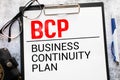 On a light-colored office table is a computer, text BCP Business Continuity Plan Royalty Free Stock Photo