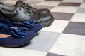 Light and comfortable blue women`s shoes and man`s shoes on  black and white checkered floor Royalty Free Stock Photo