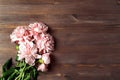 Light coral color peony flowers bouquet on wood table. with copy space for your text top view and flat lay style