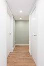 Light corridor with entrances to rooms with doors and turning to the right. Concept of renovation and moving into a Royalty Free Stock Photo