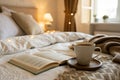 Light cozy bedroom, Coffee or tea cup and an open book on the bed Royalty Free Stock Photo