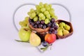 Light and dark grapes in a wooden bowl with an apple pear plum and figs on a white background.Fruit still life Royalty Free Stock Photo