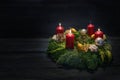 Light in the dark on third advent, natural green wreath with red candles, three are burning, Christmas decoration and cookies, Royalty Free Stock Photo