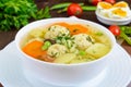 Light dietary soup with meat balls, vegetables, fusilli and boiled eggs on a dark wooden table Royalty Free Stock Photo