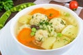 Light dietary soup with meat balls, vegetables, fusilli and boiled eggs on a dark wooden table. Royalty Free Stock Photo