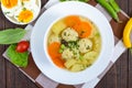 Light dietary soup with meat balls, vegetables, fusilli and boiled eggs on a dark wooden table. Royalty Free Stock Photo