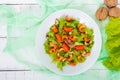 Light dietary spicy salad of lettuce, seafood crawfish, shrimp and walnuts on a white wooden background.