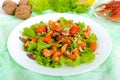 Light dietary spicy salad of lettuce, seafood crawfish, shrimp and walnuts on a white wooden background.