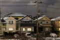 Light dusting of snow on suburban houses with lights on at night Royalty Free Stock Photo