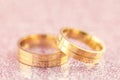 Light Elegant wedding background - two golden rings on sparkle background Royalty Free Stock Photo