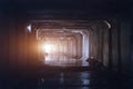 Light at the end of dark flooded dirty sewer tunnel. Turn of tunnel Royalty Free Stock Photo