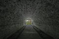 Light at end of dark tunnel. Exit from old stone underpass to green forest Royalty Free Stock Photo