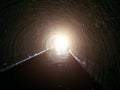 Light at end of round flooded sewer tunnel. Exit from sewer system Royalty Free Stock Photo