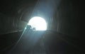 Tunnel, light at the end of it, cars driving. Yalta-Sebastopol highway, Crimea Royalty Free Stock Photo