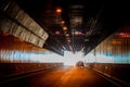 The light at the end of the tunnel - Cars nearing the end of a long tunnel with light reflecting off the side and roadway in Royalty Free Stock Photo