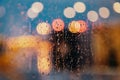 Light of evening city and rain drops on the window. Abstract blurred background Royalty Free Stock Photo