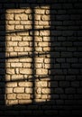 Light filters through a window, casting a rectangular shadow on a stone wall. The stones are Royalty Free Stock Photo