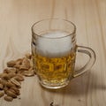 Light foaming beer and fried nuts Royalty Free Stock Photo