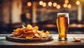 Light foamy beer with potato crisps on bar background, chips snack and cold bar beverage, food and drink Royalty Free Stock Photo