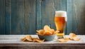 Light foamy beer, potato crisps on wooden background, chips snack and cold bar beverage, food and drink Royalty Free Stock Photo