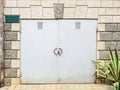 Light garage door with a padlock in the wall of a house with rough decorative masonry Royalty Free Stock Photo