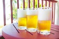 Light golden beer in glasses..Three steamed glasses with cold beer on a wooden table..Purple-red color table with drinks on the ba Royalty Free Stock Photo