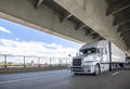 Light gray big rig semi truck transporting cargo in refrigerator semi trailer driving on the two level transportation Fremont Royalty Free Stock Photo
