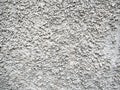 Light gray grainy stucco creates an abstract pattern on the wall. Stone background Royalty Free Stock Photo