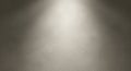 A light gray, textured plaster wall illuminated by a soft, focused spotlight from above. The Royalty Free Stock Photo