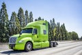 Light green big rig professional semi truck tractor driving on the wide multiline highway road to warehouse for pick up loaded Royalty Free Stock Photo