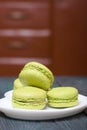 Light green macarons lie on a saucer. On pine planks with a crisp woody texture Royalty Free Stock Photo